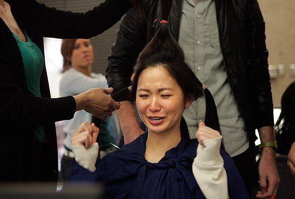 Angela Hsu, a junior at UCLA, braces herself before having 14 inches of her hair cut off during the 2nd annual Locks of Love event at the campus in Westwood.