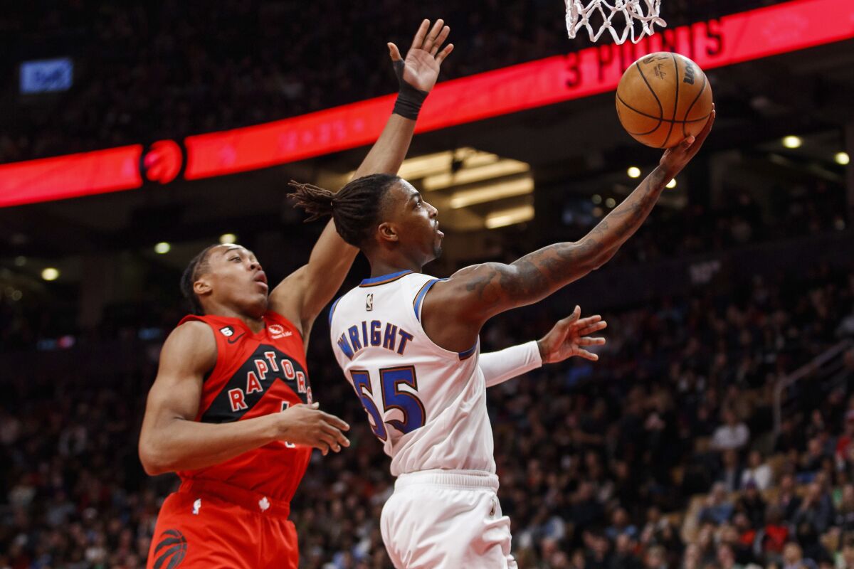 Washington Wizards guard Delon Wright (55) drives to the net against Toronto Raptors forward Scottie Barnes (4) during the first half of an NBA basketball game in Toronto, Sunday, March 26, 2023. (Cole Burston/The Canadian Press via AP)