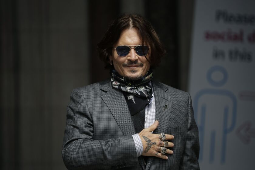 FILE - In this Thursday, July 23, 2020 file photo, U.S. actor Johnny Depp gestures to fans and the media as he arrives at the High Court in London. Spain’s most high-profile group of female filmmakers denounced the San Sebastian film festival’s decision to award Johnny Depp its highest honor for acting on Monday Aug. 9, 2021. The move gives the festival a bad name after a British judge ruled allegations of domestic violence against Depp were “substantially correct”, it says. (AP Photo/Matt Dunham, file)