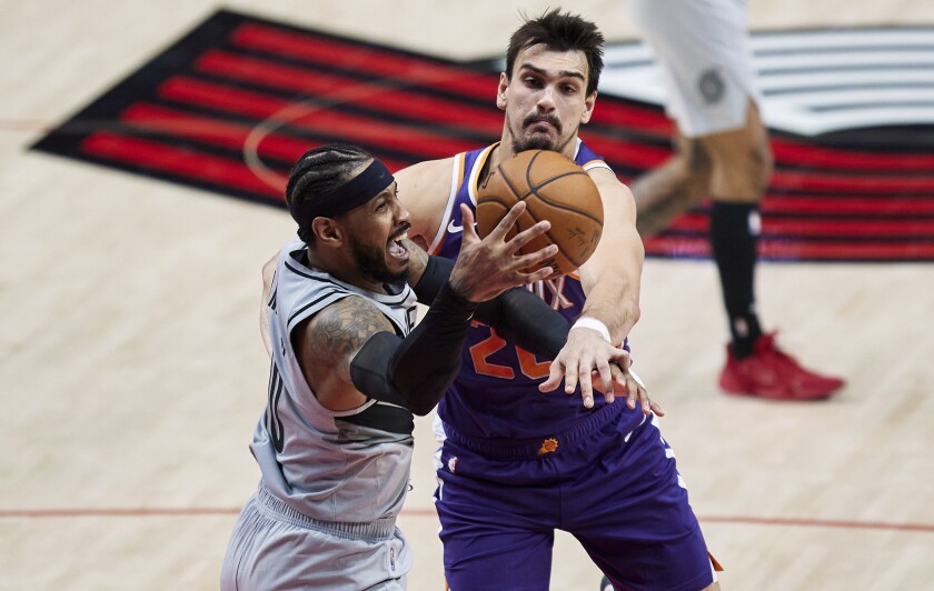 Portland Trail Blazers forward Carmelo Anthony, left, and Phoenix Suns forward Dario Saric vie for a rebound during the second half of an NBA basketball game in Portland, Ore., Thursday, March 11, 2021. (AP Photo/Craig Mitchelldyer)