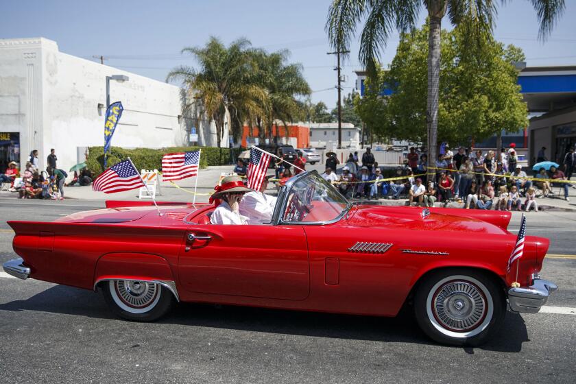 A vintage Ford Thunderbird following a parade route is a reminder of the community's heyday.