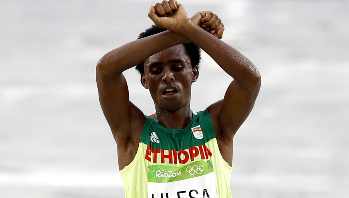 Ethiopia's Feyisa Lilesa crosses the finish line of the men's marathon with arms crossed above his head to show solidarity with the resistance movement in his homeland.