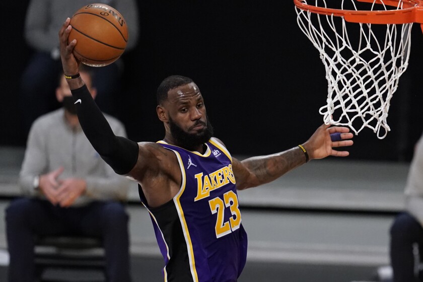 Lakers forward LeBron James grabs a rebound against the Hornets.