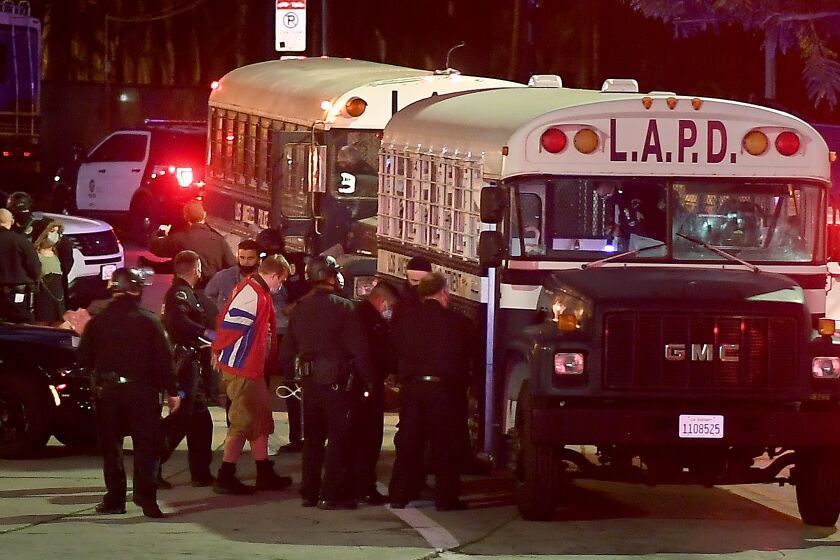 LOS ANGELES CALIFORNIA MARCH 25, 2021-Protestors board an LAPD bus afgter being arrested in Echo Park Thursday. County officials are evicting the homeless from Echo Park. (Wally Skalij/Los Angeles Times)