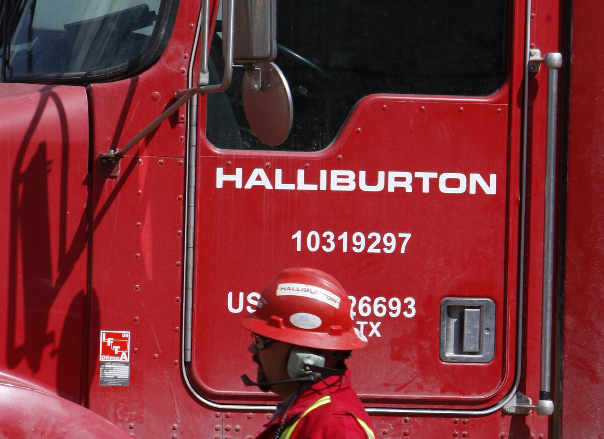 A worker passes a Halliburton truck in Rulison, Colo., in 2009.