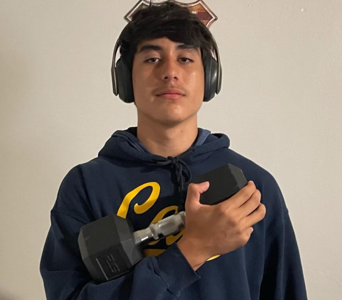 Los Angeles High's Sebastian Romero holds a dumbbell.