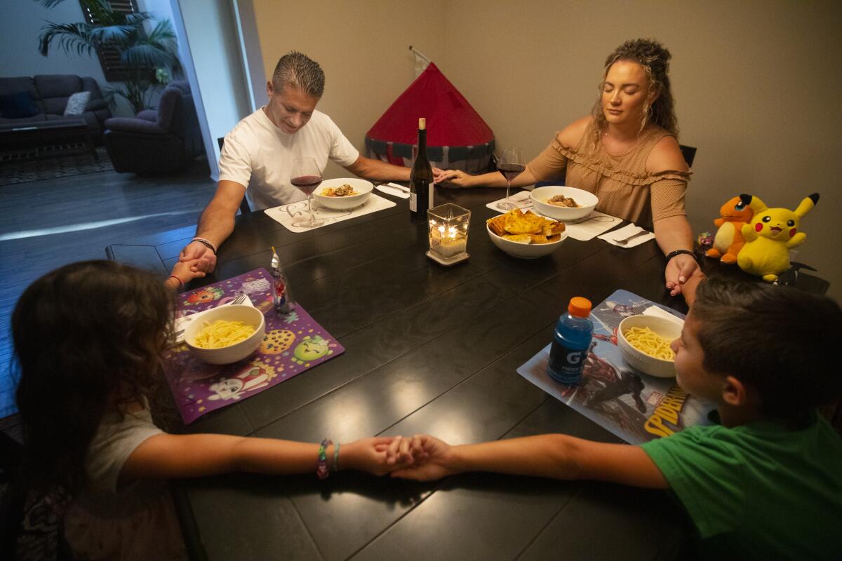 Jon and Roxanne Hatami with 4-year-old Lindsey Beth and Jon Jr., 7, before dinner in their Santa Clarita Valley home.

