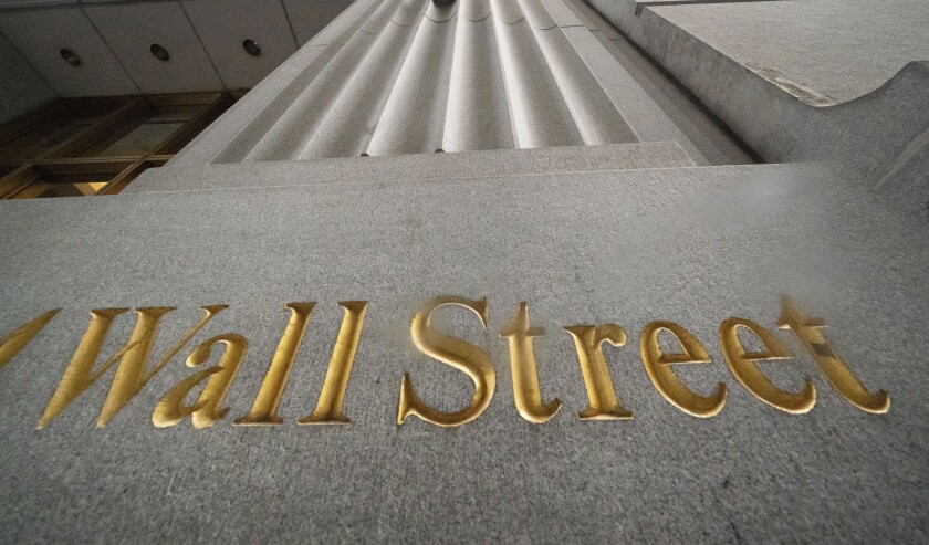 The words Wall Street are carved into the side of a building in New York. 