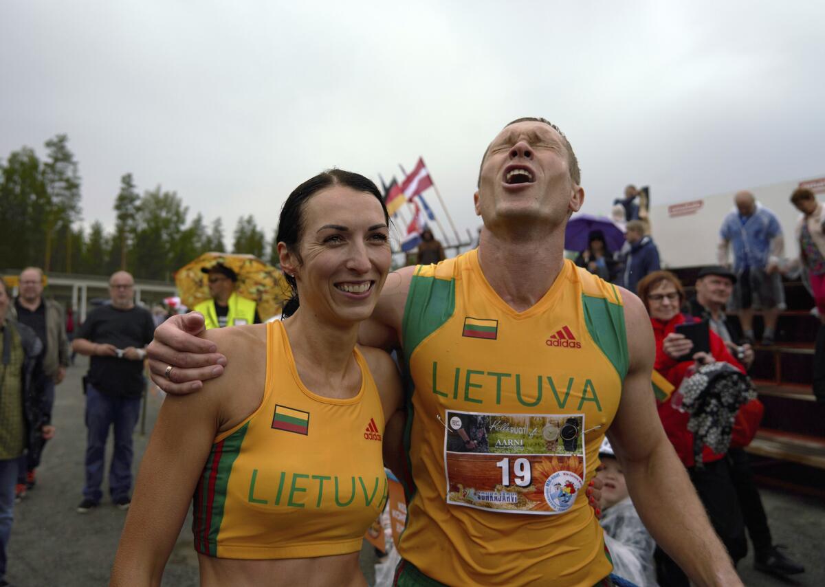 La pareja lituana Vytautas Kirkliauskas y Neringa Kirkliauskiene celebran su victoria en el campeonato mundial “cargando a la esposa” en Sonkajarvi, Finlandia.