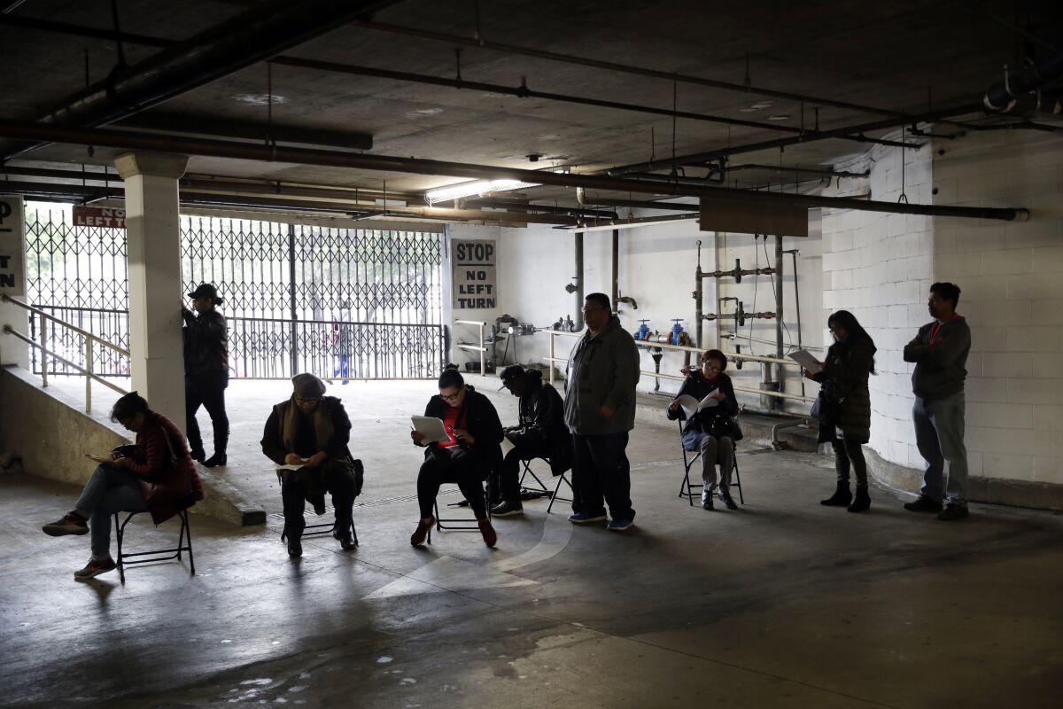 Workers wait in line in a basement garage to apply for unemployment benefits in Los Angeles.

 