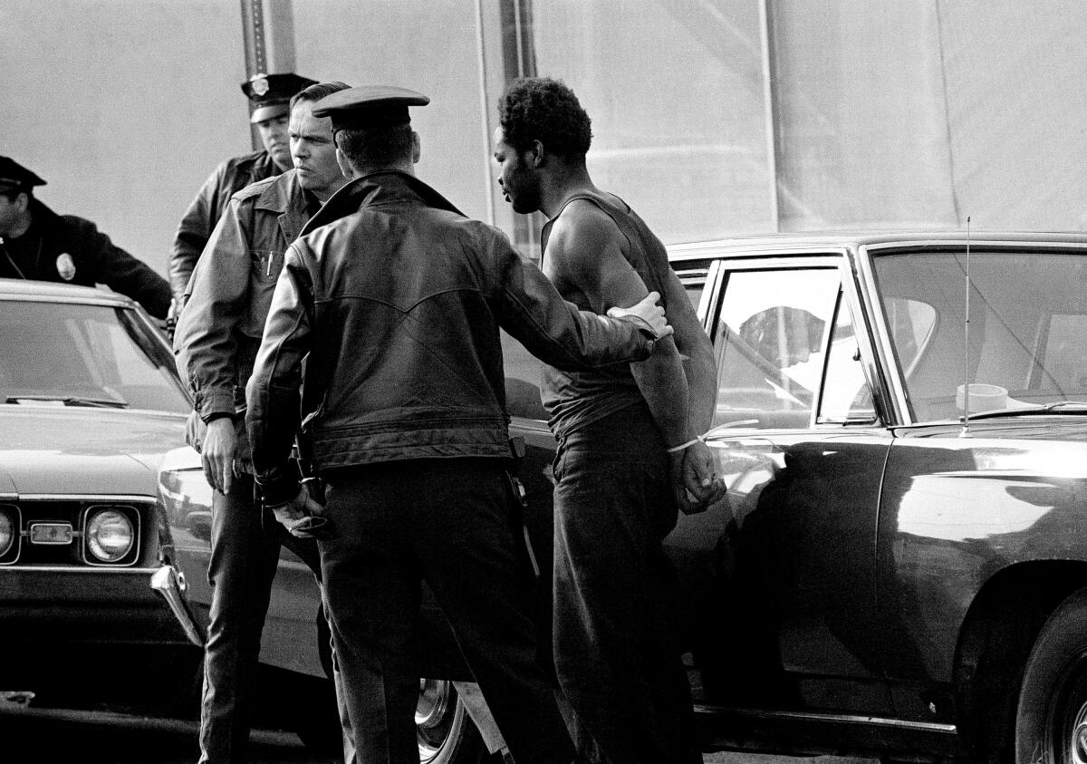 A Black Panther surrenders to police after a four-hour confrontation at the party headquarters in Los Angeles, Dec. 9, 1969.