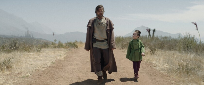 a man and girl walking on an dirt road