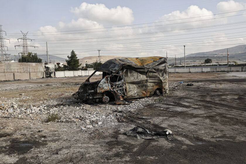 A destroyed vehicle after protesters from a nearby Roma settlement unrest overnight in Aspropyrgos, Greece, Thursday, Dec 8, 2022, following the police shooting of a Roma teenager during a police chase. Protesters in the industrial eastern Athens neighbourhood of Aspropyrgos allegedly torched a local tire business and a bus and set up burning barricades in the streets. (John Liakos/InTime News via AP)