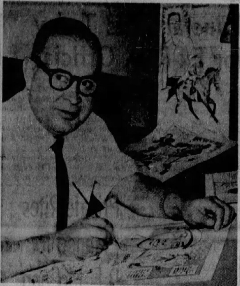 LA Times cartoonist Alex Perez with pencil in hand at his desk