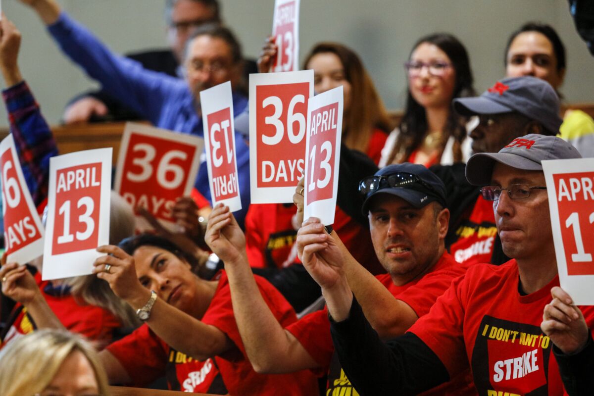 Members of the California Faculty Association (CFA) and their supporters held up signs reading "April 13" and "36 days," in reference to a possible strike by faculty, while attending the CSU Board of Trustees meeting in Long Beach.