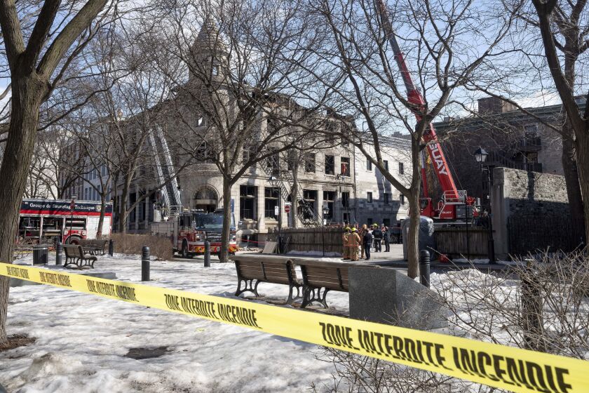 Bomberos buscan víctimas el lunes 20 de marzo de 2023 en el lugar de un incendio de la semana pasada en Montreal. (Ryan Remiorz/The Canadian Press vía AP)