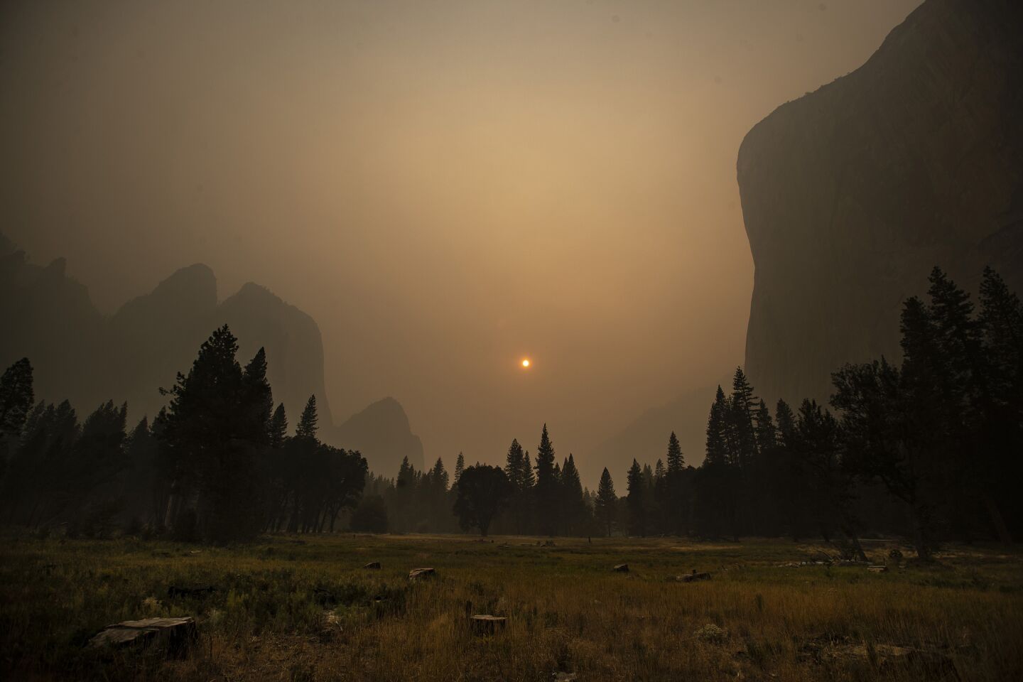 The sun is dim and shrouded in thick smoke in the Yosemite Valley.