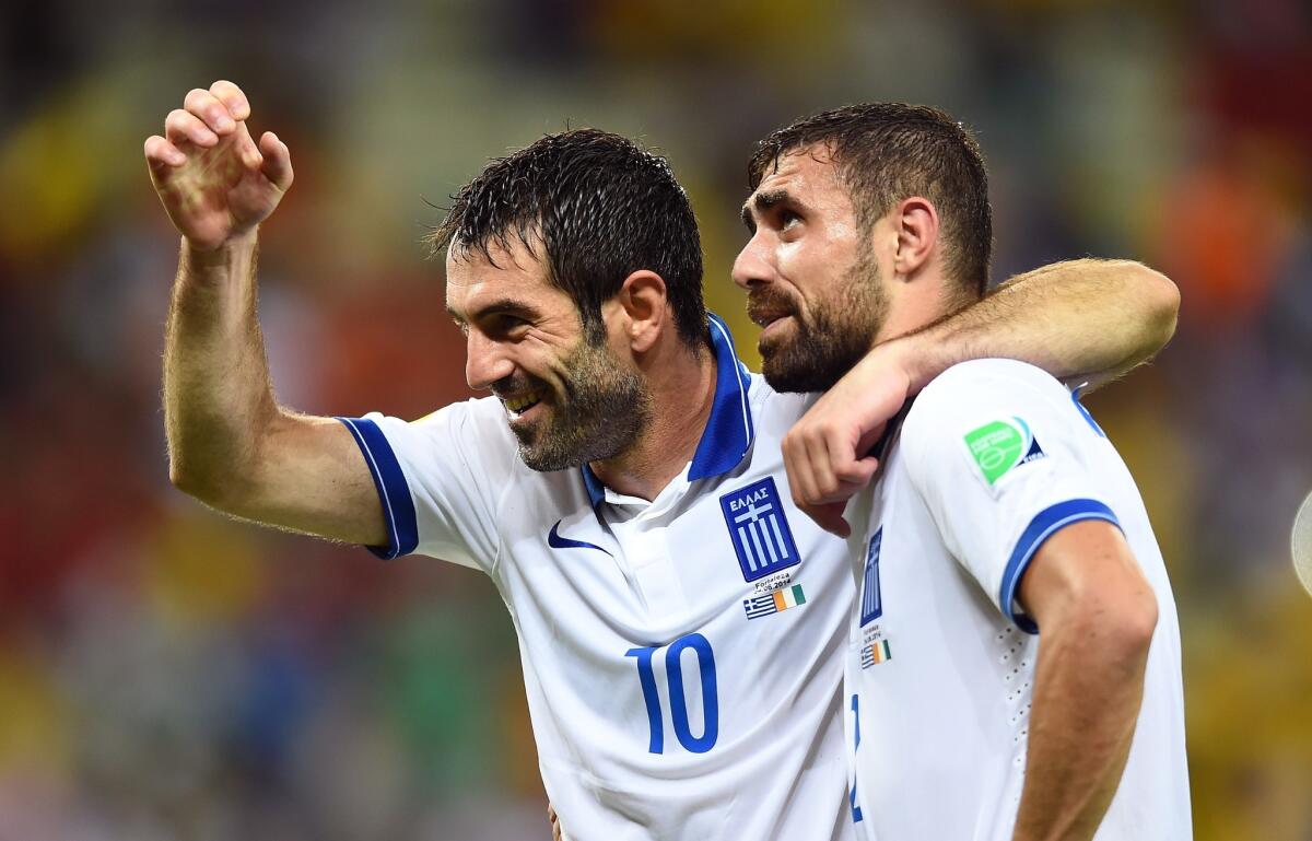 Greece's Giorgos Karagounis, left, and Ioannis "Giannis" Maniatis celebrate after a 2-1 victory over Ivory Coast on June 24.