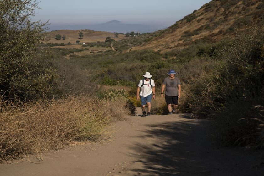 Poway, California - July 28: Steve Stone, left, and Larry Ott hike the Iron Mountain Trail on Friday, July 28, 2023 in Poway, California. Ott said he is hiking in memory of his friend who died hiking earlier in the week. The two said they drank water before the trek and are experienced backpackers and that they know their limitations when it comes to hiking in the heat. (Ana Ramirez / The San Diego Union-Tribune)