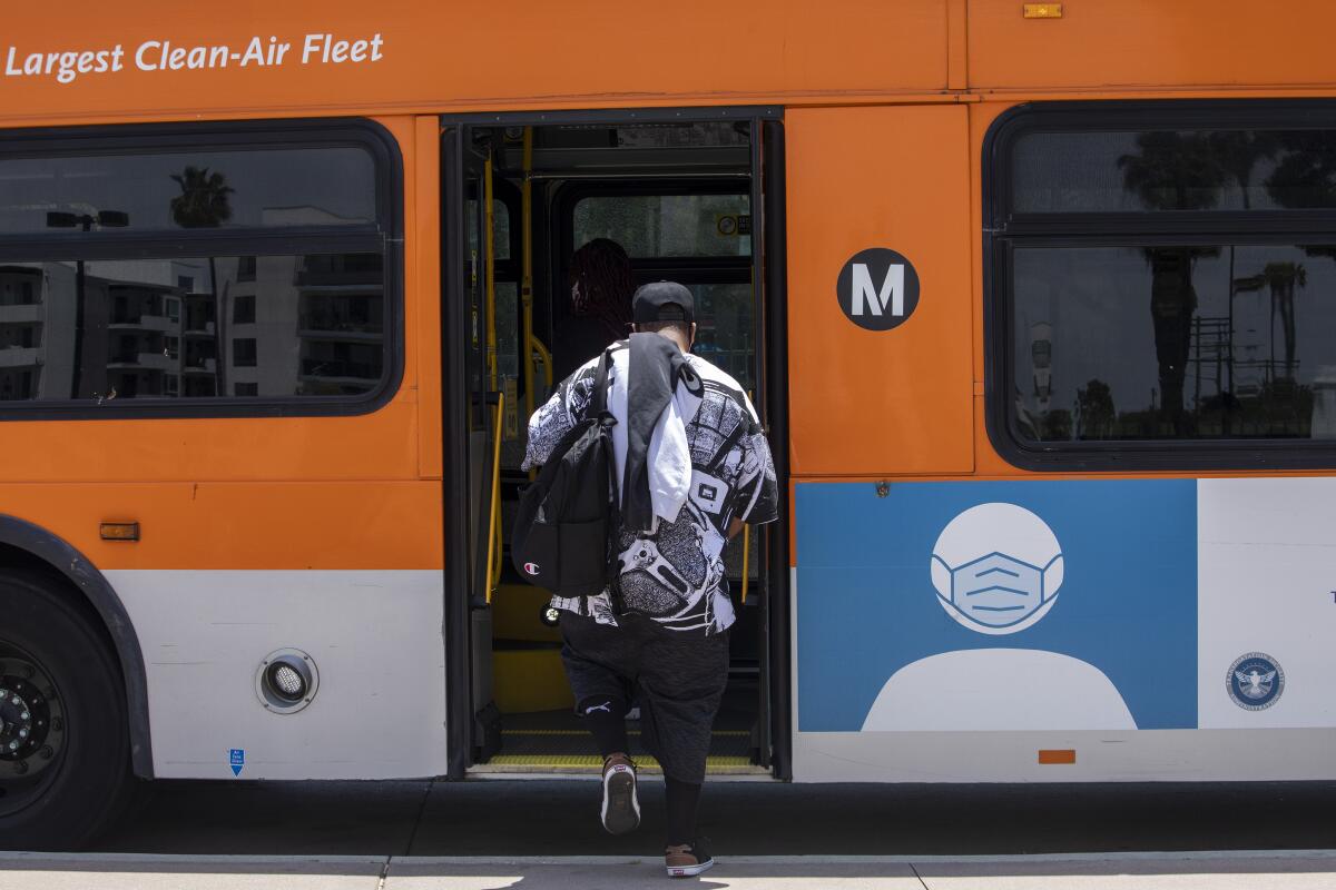  A man carrying a daypack boards a Metro bus at the back door