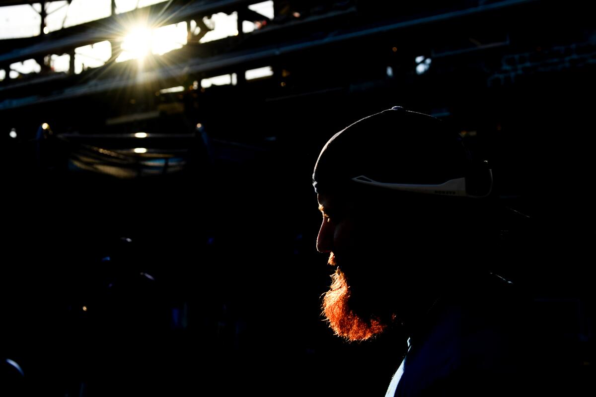 Justin Turner is in silhouette except for his red beard, which is lighted by the sun's rays.