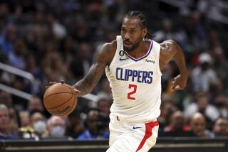 Los Angeles Clippers forward Kawhi Leonard dribbles down the court during the first half of a preseason.