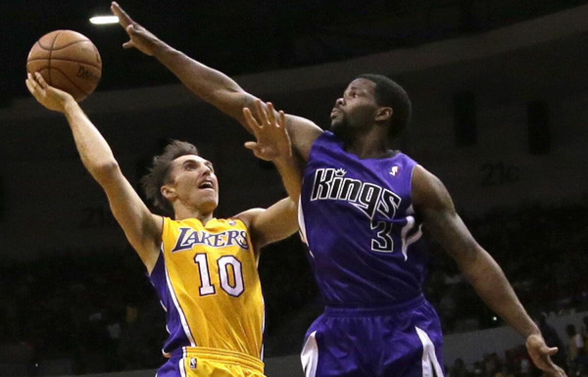 Lakers point guard Steve Nash tries to get off a shot over Kings point guard Aaron Brooks in the first half of a preseason game on Thursday night.