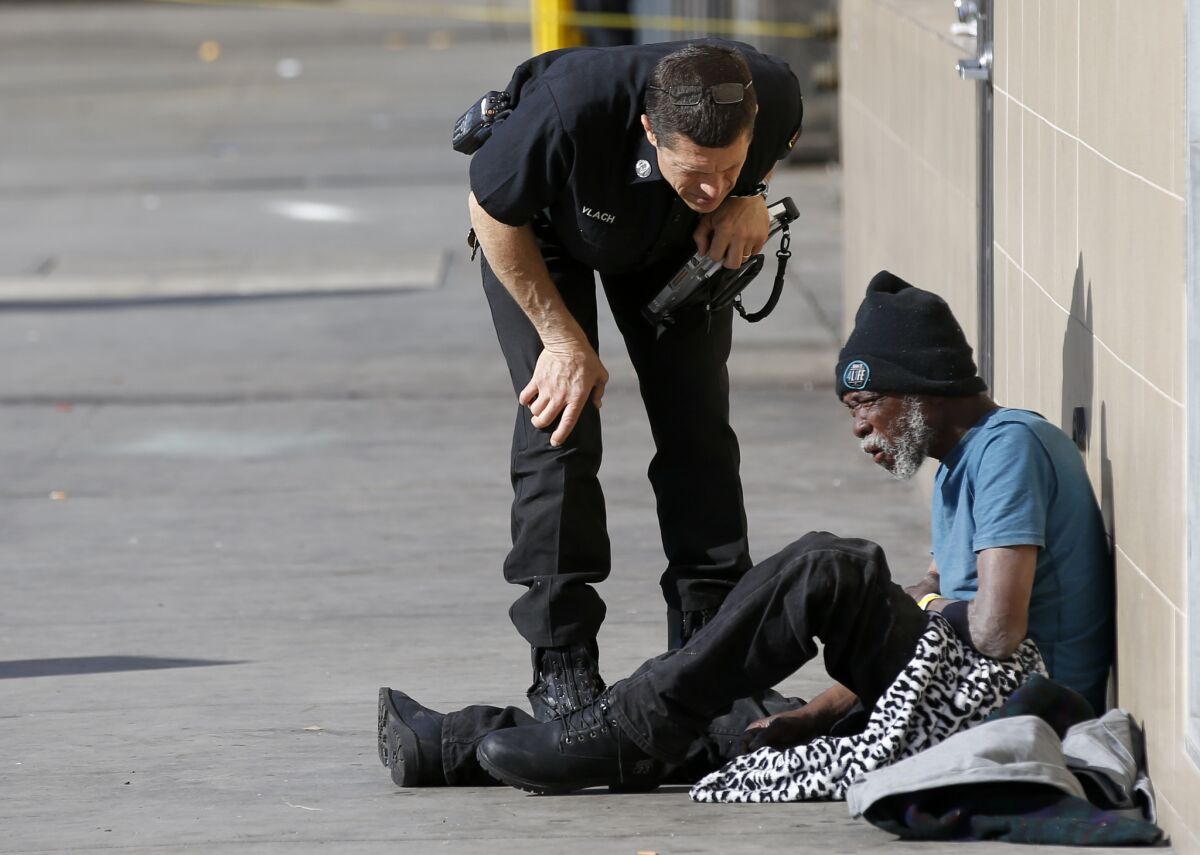 A Los Angeles Fire Department paramedic speaks with a homeless man who was too weak to stand.