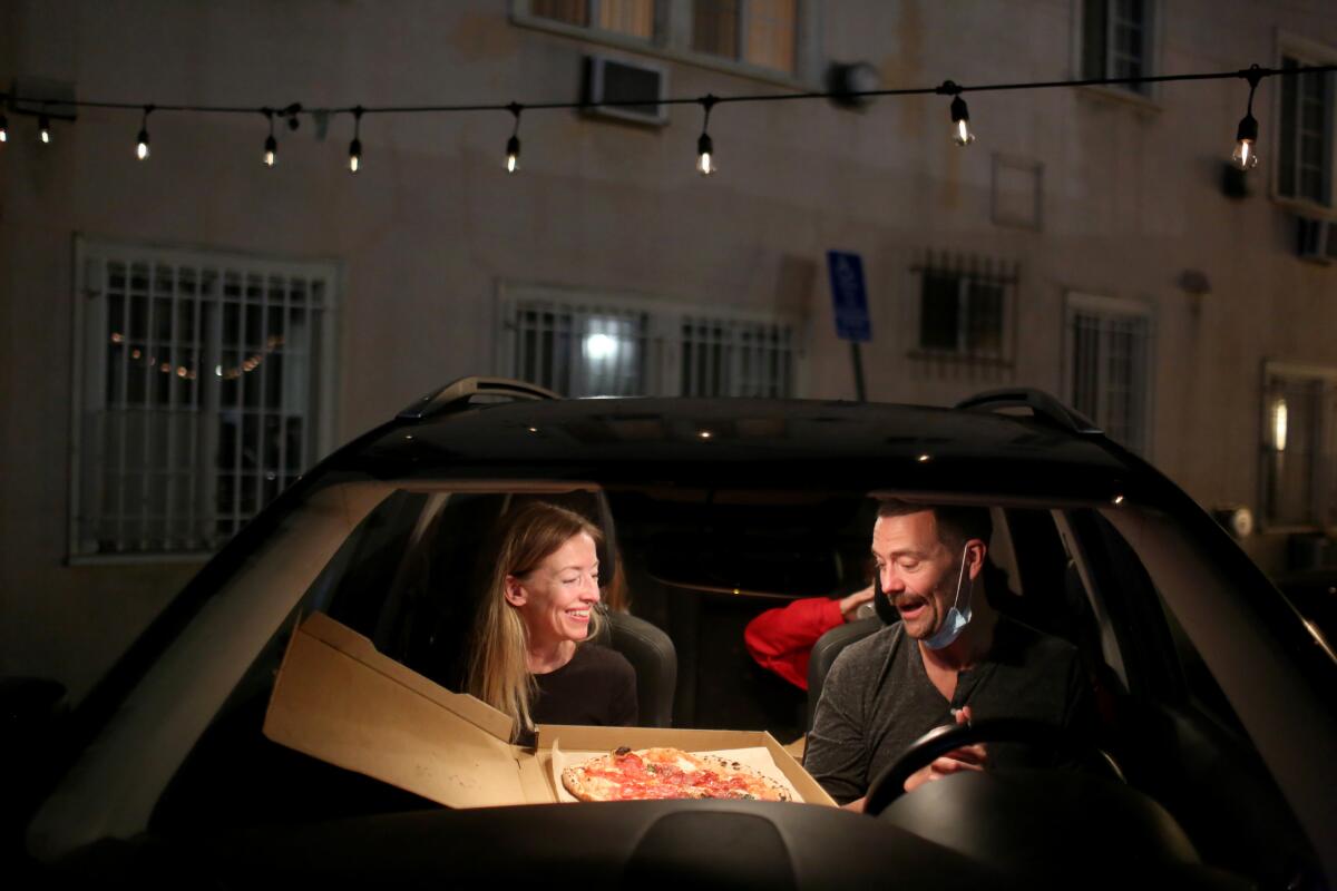 Heather Turgeon and Ben Hansford eat pizza in their car at L'Antica Pizzeria da Michele.