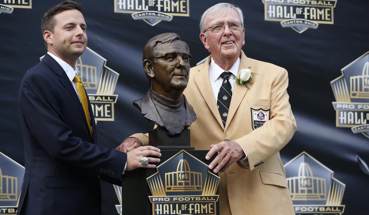 Ron Wolf, right, and his son Eliot pose with Wolf's bust during his Pro Football Hall of Fame induction on Aug. 8, 2015.