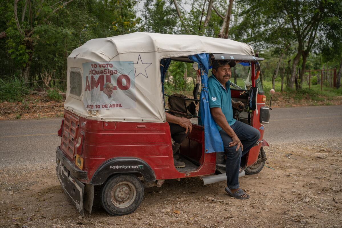 Ardelio Morales Martinez sits in his taxi on a road.