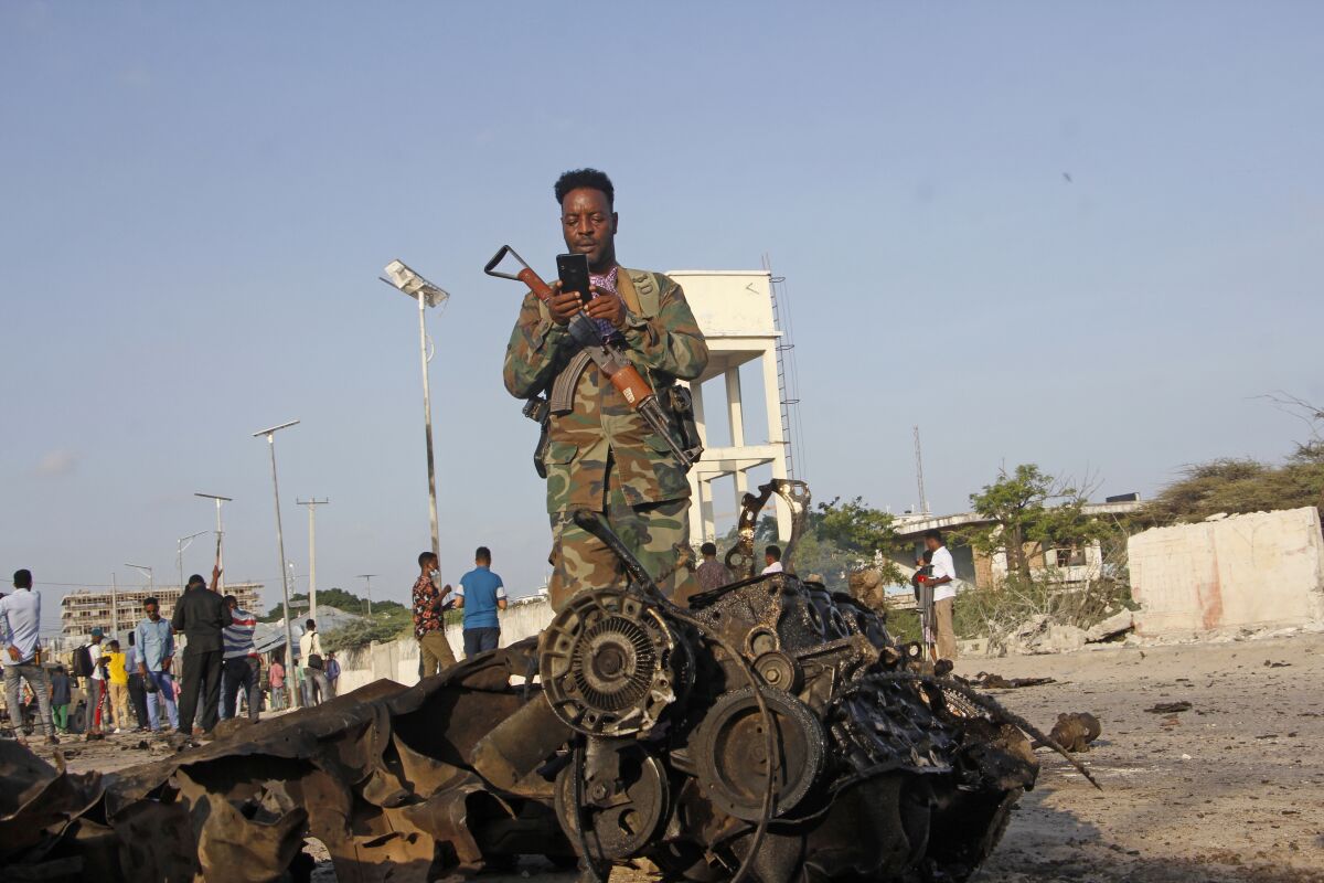 Soldiers secure the area near the wreckage of a vehicle after a suicide car bomb attack on a convoy in Mogadishu, Somalia, Thursday Nov.11, 2021, (AP Photo/Farah Abdi Warsameh)