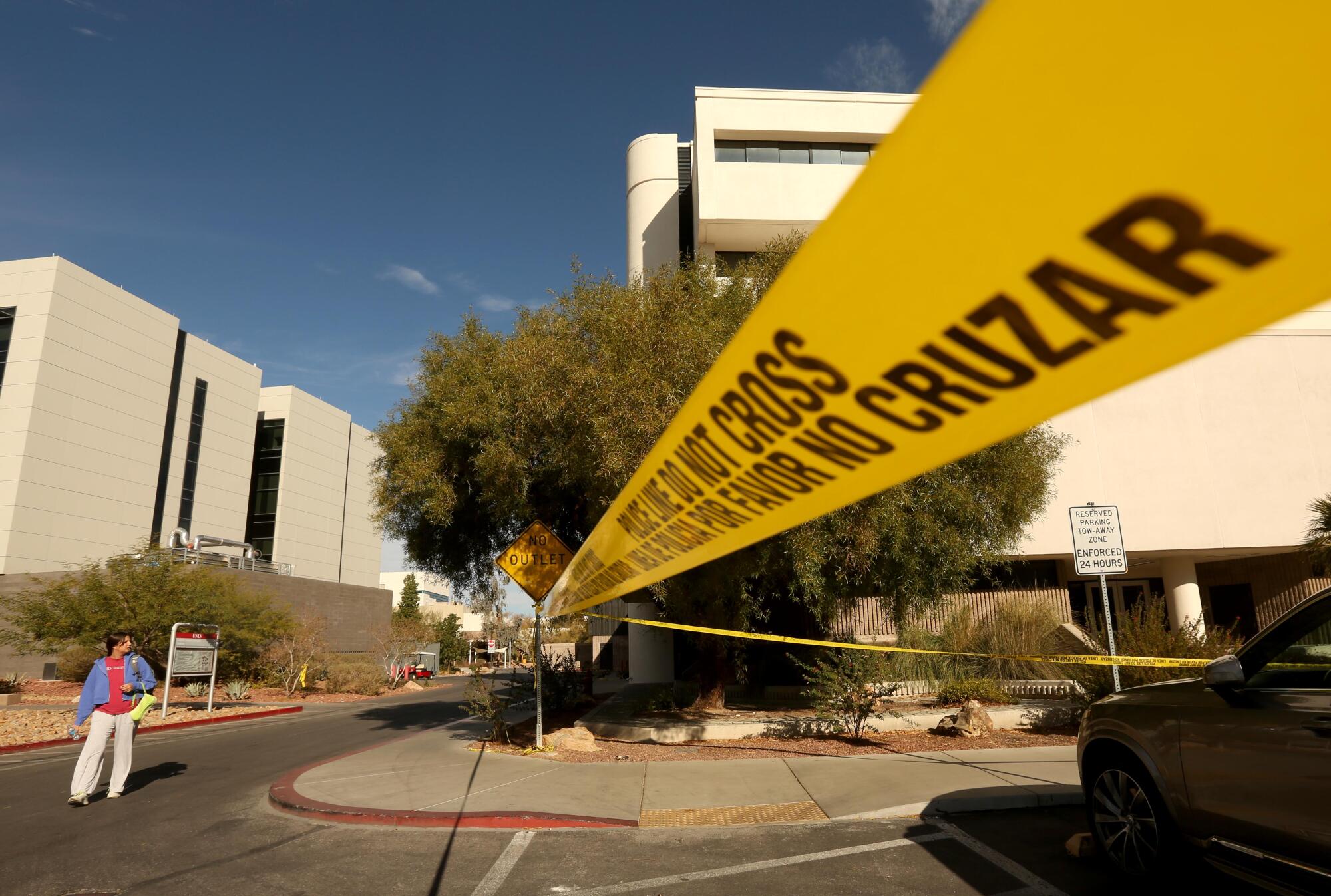 A student walks past police tape outside UNLV's Frank and Estella Beam Hall, where the shooting took place.