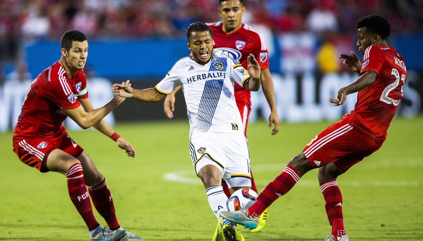 FC Dallas' Kellyn Acosta (23) steals the ball from Los Angeles Galaxy's Giovani Dos Santos (10) near FC Dallas' Matt Hedges (24), left, and FC Dallas' Victor Ulloa (8) during an MLS soccer match Saturday, Aug. 15, 2015, in Frisco, Texas. (Ashley Landis/The Dallas Morning News via AP) MANDATORY CREDIT; MAGS OUT; TV OUT; INTERNET USE BY AP MEMBERS ONLY; NO SALES