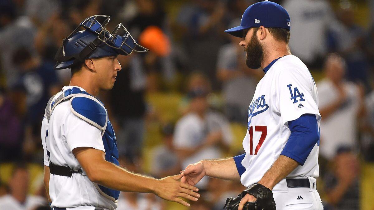 Dodgers catcher Austin Barnes, left, shakes hands with pitcher Brandon Morrow after earning a save in the ninth inning against the Angels at Dodger Stadium on June 27.