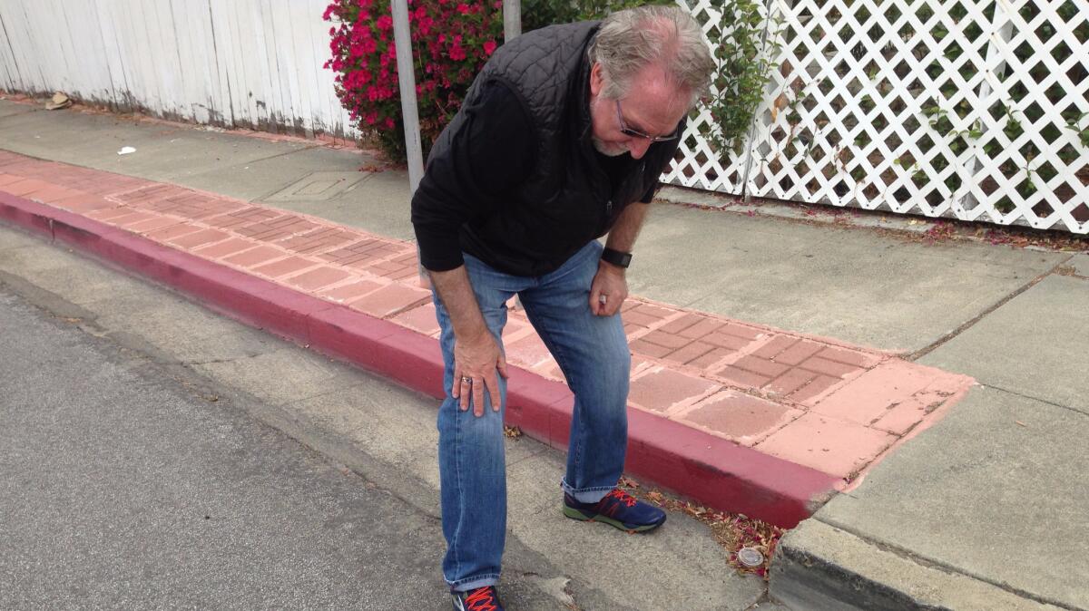 A few weeks before its surprise, unceremonious destruction, U.S. Geological Survey research geologist David Schwartz on June 7, 2016, shows how a curb has been pulled apart over the decades by the powerful seismic forces of the Hayward fault.