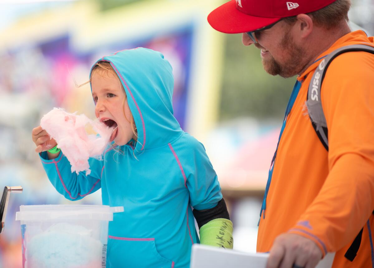 Jeff Haluck watches his son Finley indulge in cotton candy during opening day at the OC Fair on Friday.