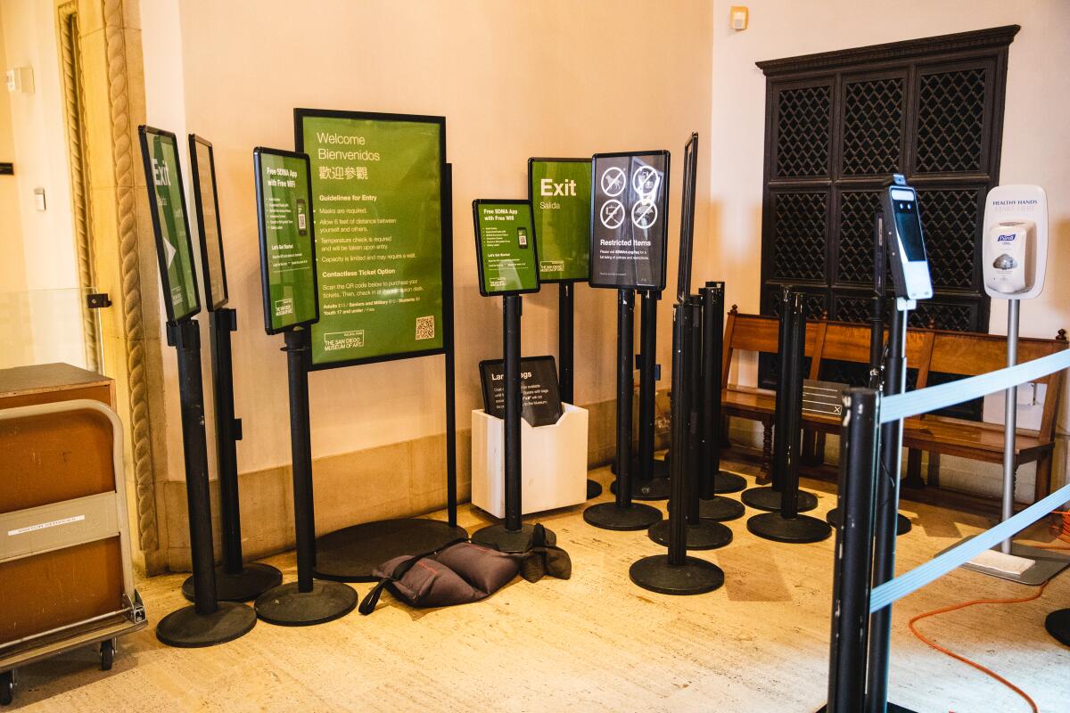 Directional signs and hand sanitizer stations at the San Diego Museum of Art on Wednesday.