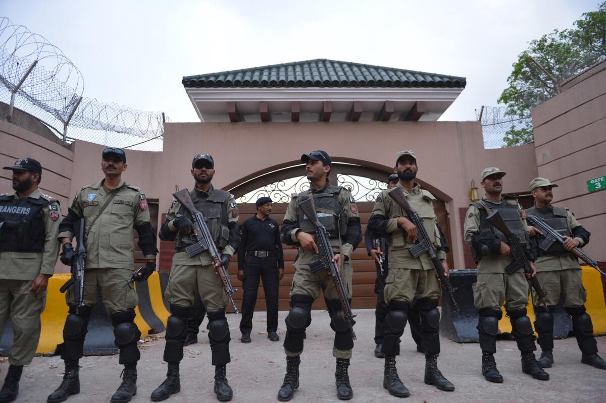 Pakistani paramilitary soldiers stand guard last week outside the residence where former President Pervez Musharraf is being held under house arrest. A court on Tuesday banned Musharraf from Pakistani politics for life.