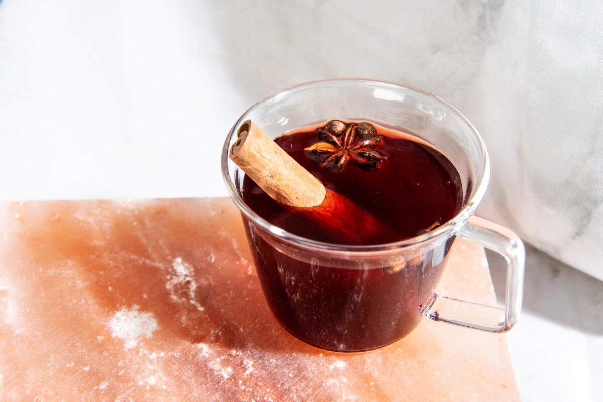 Mulled Pomegranate Juice in a glass mug with a cinnamon stick in it