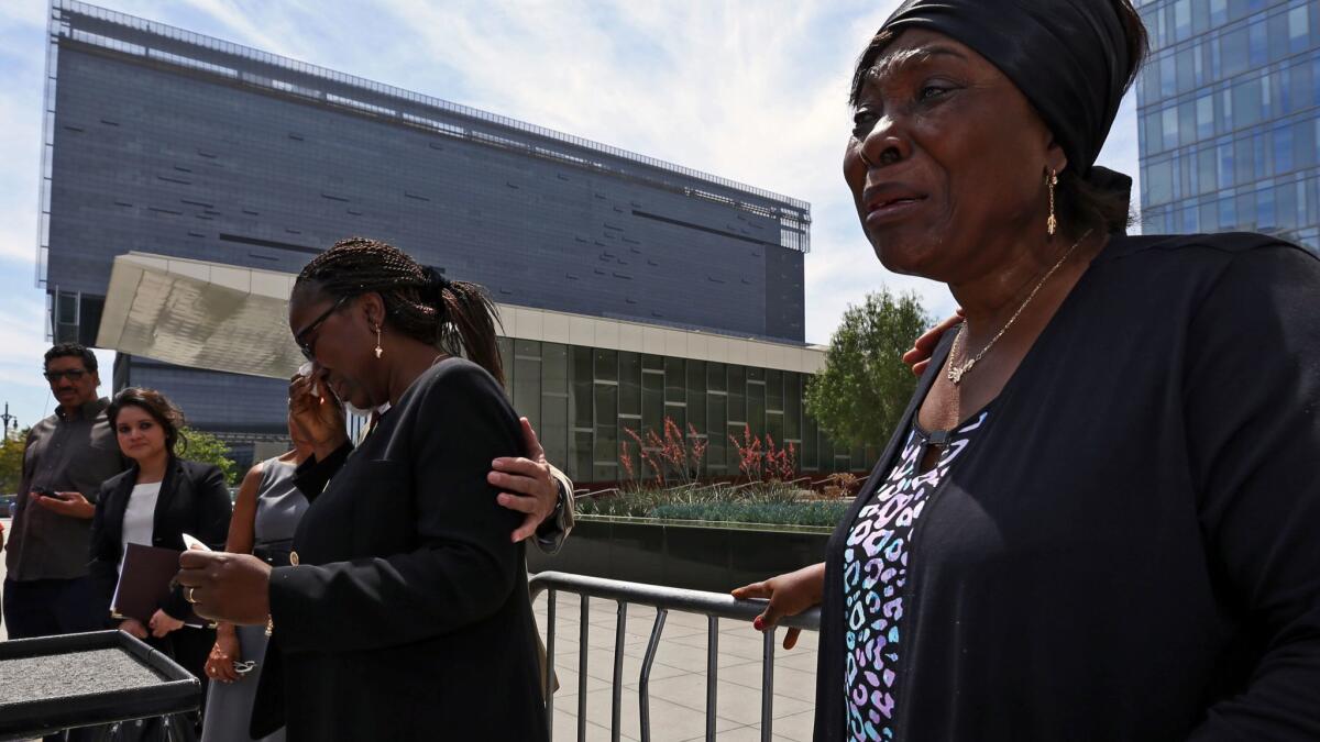 Heleine Tchayou, right, mother of Charly Leundeu Keunang, a homeless man shot and killed by LAPD on skid row, weeps as Keunang's sister Line Marquise Foming addresses a news conference about the family's lawsuit in 2016.