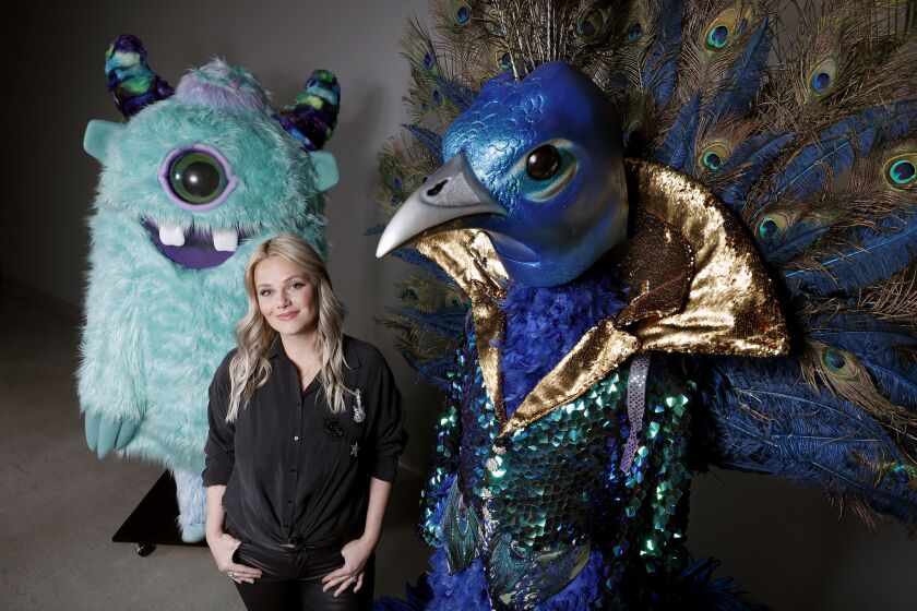 NORTH HOLLYWOOD, CALIF. -- TUESDAY, JANUARY 22, 2019: Marina Toybina, costume designer, for "The Masked Singer" poses for a portrait with costumes; Monster and the Peacock, in North Hollywood, Calif., on Jan. 22, 2019. Ã¬The Masked Singer" is Fox's wacky news singing competition that has viewers hooked. The show features celebrity contestants that compete while donning elaborate costumes, complete with bulky headgear. (Gary Coronado / Los Angeles Times)