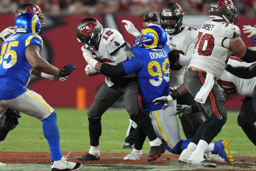 Los Angeles Rams defensive tackle Aaron Donald (99) sacks Tampa Bay Buccaneers quarterback Tom Brady (12) during the second half of an NFL football game between the Los Angeles Rams and Tampa Bay Buccaneers, Sunday, Nov. 6, 2022, in Tampa, Fla. (AP Photo/Chris O'Meara)