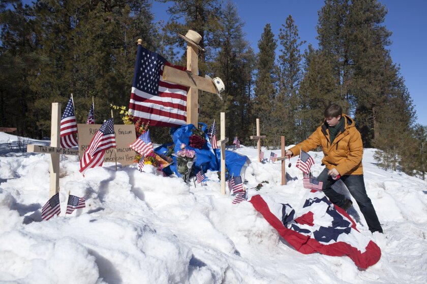 Tully Joe of Twin Falls, Idaho, adds a cross to a memorial at the site where Robert "LaVoy" Finicum was shot and killed by federal agents on Jan. 26 in eastern Oregon. Sixteen people involved in the occupation of the Malheur National Wildlife Refuge were indicted by a federal grand jury.