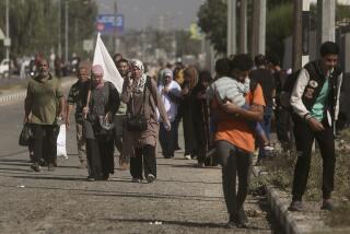 Una mujer carga con una bandera blanca para evitar recibir disparos mientras palestinos huyen de la Ciudad de Gaza hacia el sur de la Franja, en la calle Salah al-Din, en Bureij, el 7 de noviembre de 2023. (AP Foto/Mohammed Dahman)