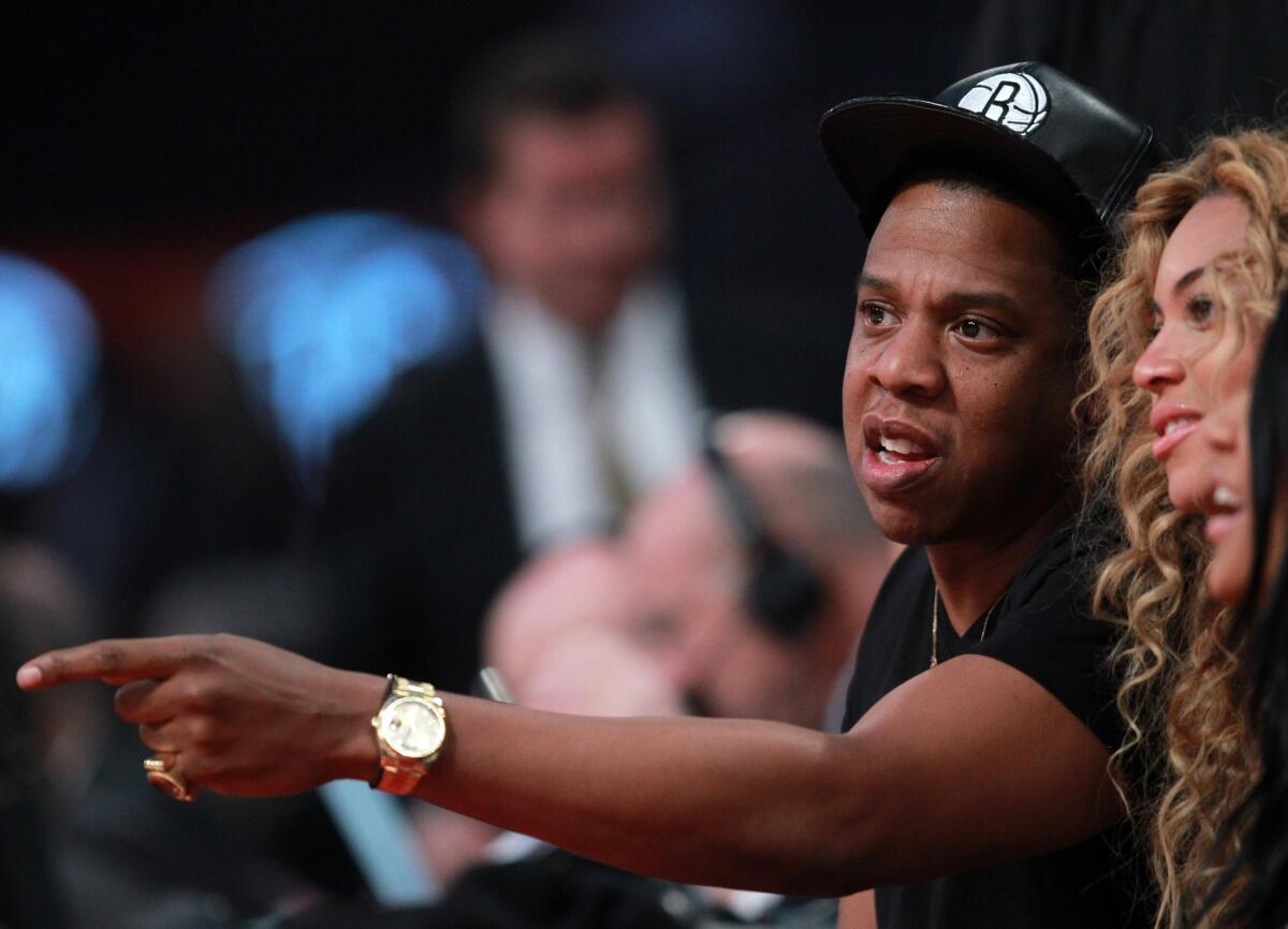 Jay-Z sits with wife Beyonce at the NBA All-Star game in Houston in February.