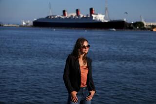 LONG BEACH, CA - JULY 31, 2024 - Diana Michaelson, 19, across the way from the Queen Mary in Long Beach on July 31, 2024. Michaelson was a 16-year-old junior at Long Beach Polytechnic High School, now attending Cornell University, who has been worried about climate change. That's when she learned her hometown of Long Beach would be facing serious sea level rise by the time she's 25. "We have to act now. We Can't wait for future generations," said Michaelson. (Genaro Molina/Los Angeles Times)