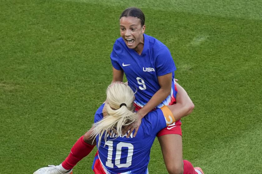 Mallory Swanson, of the United States, up, celebrates with Lindsey Horan.