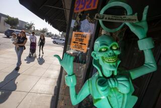 BURBANK, CA - October 10, 2022 - Customers walk past a window on their way into the Halloween Town store Monday, Oct. 10, 2022 in Burbank, CA. (Brian van der Brug / Los Angeles Times)