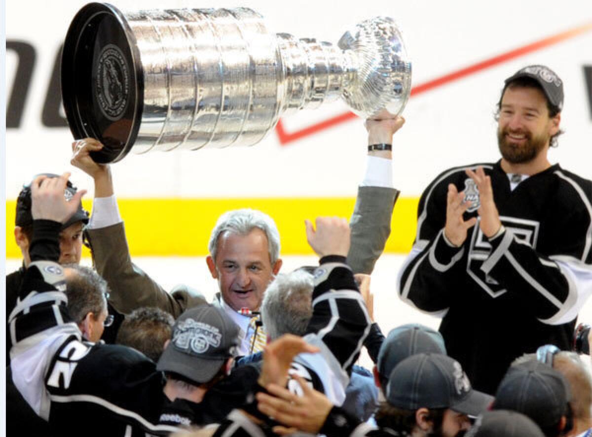 Kings Coach Darryl Sutter, shown hoisting the Stanley Cup trophy in June, says injuries have had a lot to do with the team's early struggles.
